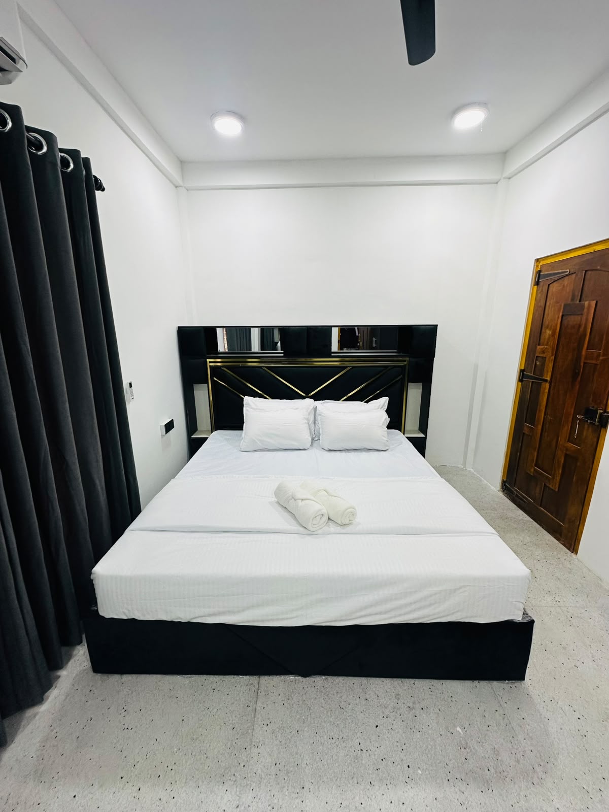 Bedroom with white linens and black feature headboard