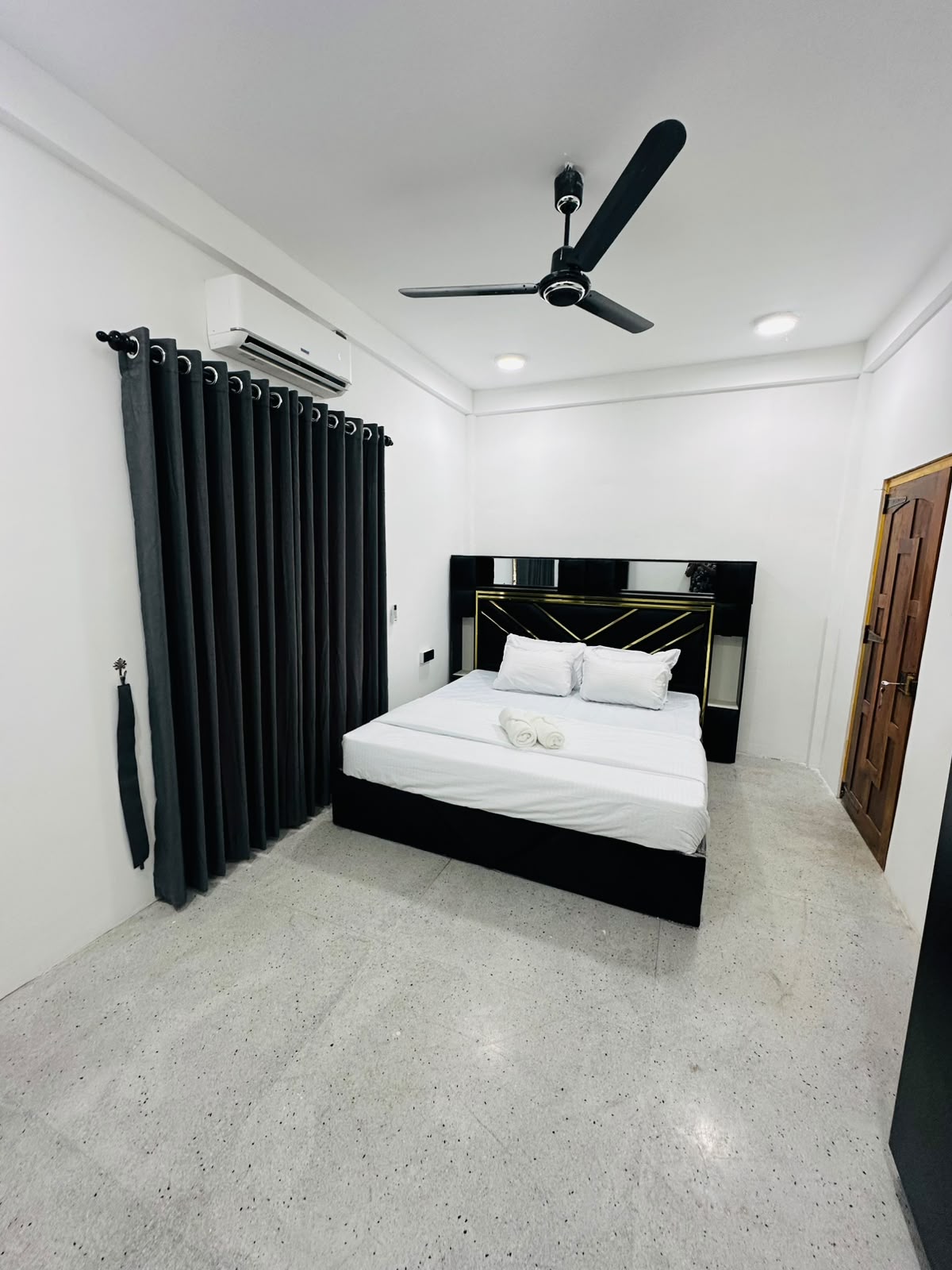 Bedroom angled toward the wardrobe and curtained window